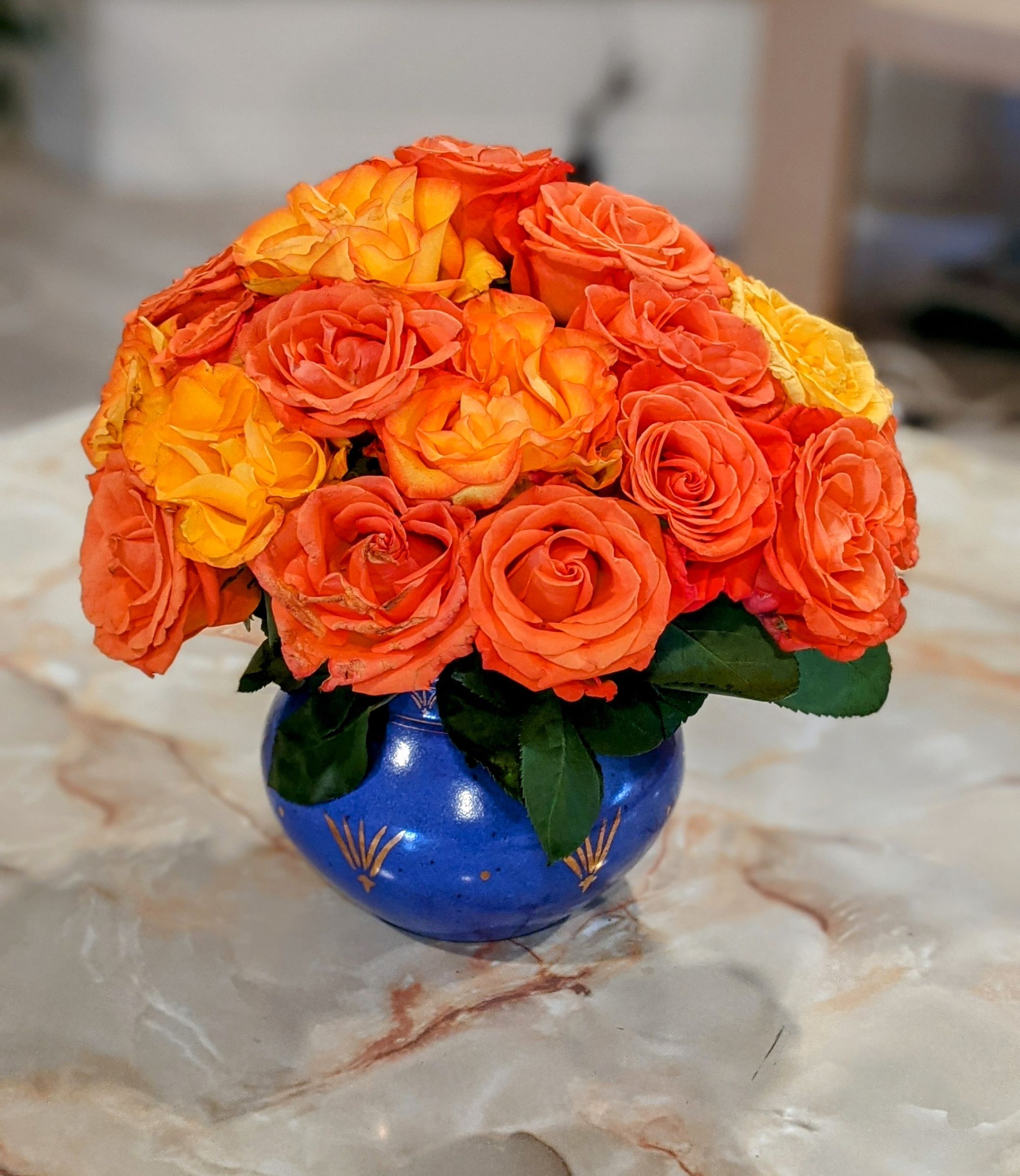 Orange roses arranged in a cobalt blue vase