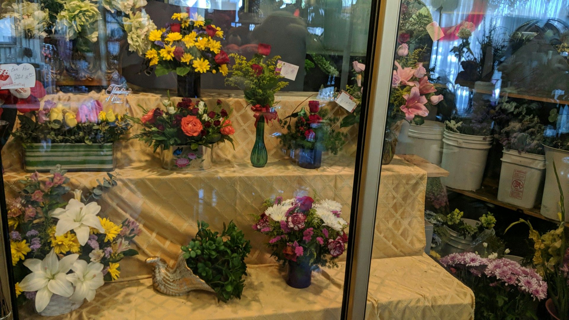 The flower cooler inside the shop, stocked with arrangements